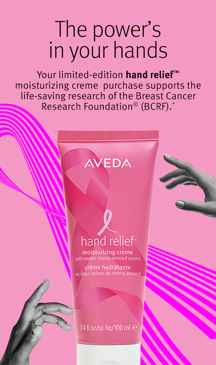 A pink tube of Aveda Hand Relief moisturizing creme is displayed against a pink background with text about supporting breast cancer research. | Anaala Salon and Spa, Madison WI