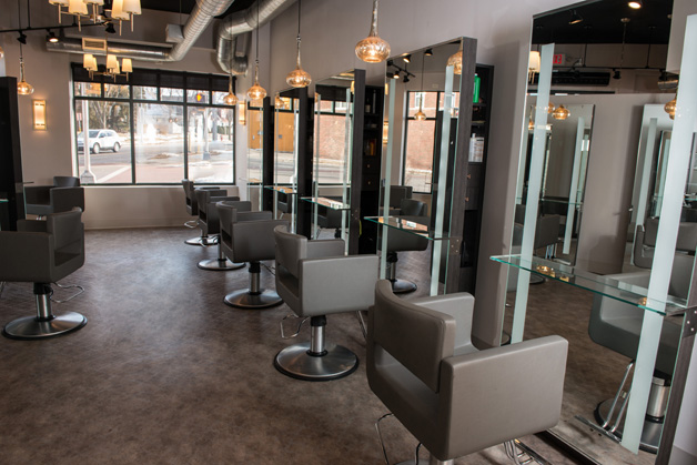 Modern hair salon with empty gray chairs, mirrors, and pendant lights. Large windows provide natural light, and the salon appears clean and organized—experience services from top hair color specialists Madison WI. | Anaala Salon and Spa, Madison WI